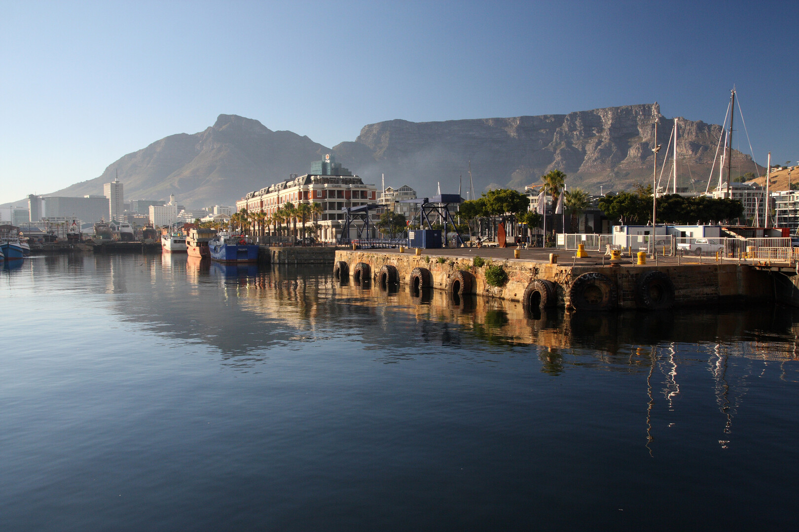Boats and waterfront promenade at the V&A Waterfront in Cape Town with Table Mountain backdrop